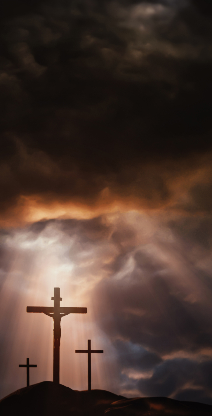 The three holy crosses of Jesus Christ shining through the red sky and clouds and bright rays background